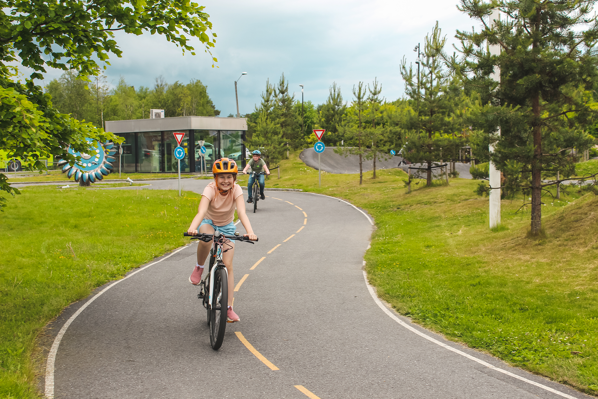 Jente som sykler i uteparken på Inspiria